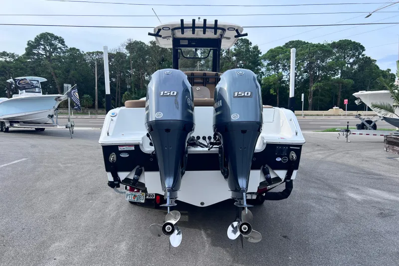 Slide: The Image of 2023 Sea Hunt Ultra 265 SE boat with dual Yamaha 150 engines, parked outdoors. - 6