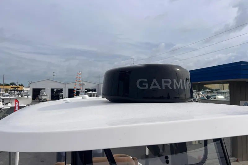 Slide: The Image of 2023 Sea Hunt Ultra 265 SE with Garmin radar on top, in a marina setting. - 7