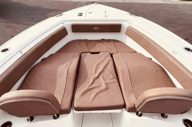 Slide: The Image of 2023 Sea Hunt Ultra 265 SE boat with spacious brown cushioned seating area. - 8