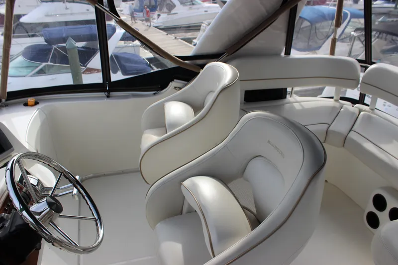 Slide: The Image of Interior of 2007 Silverton 36 Convertible yacht with plush white seating and steering wheel. - 10
