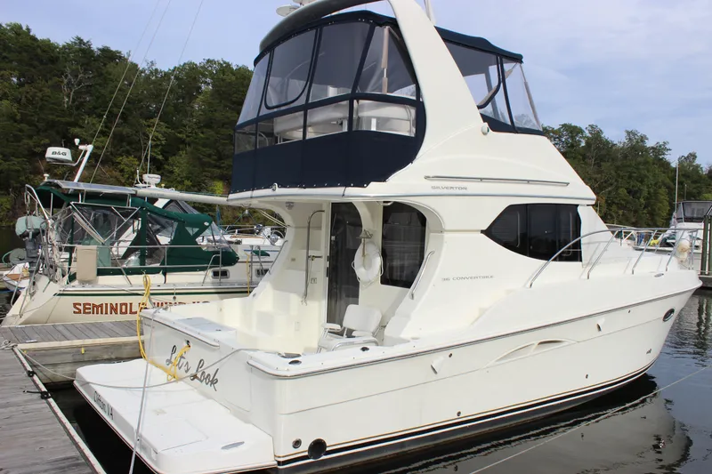 Slide: The Image of 2007 Silverton 36 Convertible yacht docked at marina, featuring sleek design and spacious deck. - 2