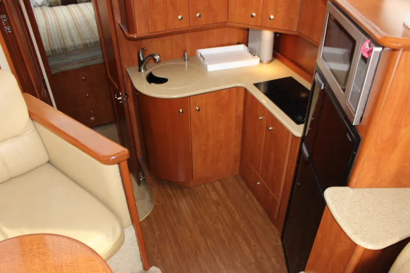 Slide: The Image of 2007 Silverton 36 Convertible yacht interior with kitchenette, featuring wood cabinetry and modern appliances. - 27