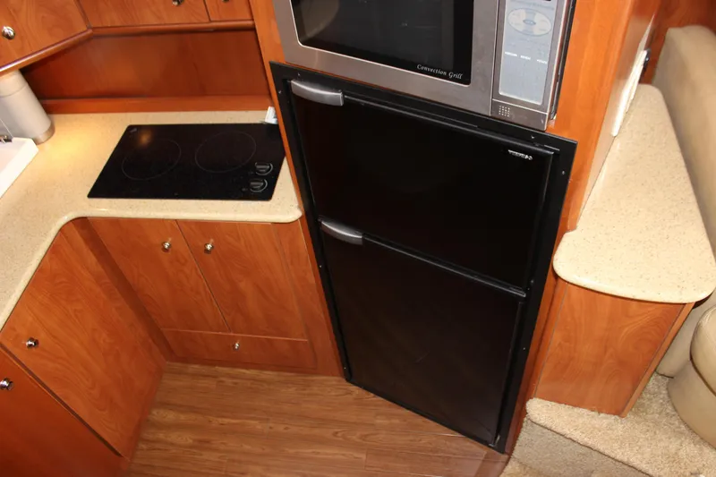 Slide: The Image of 2007 Silverton 36 Convertible yacht kitchen with stove, microwave, and fridge. - 28