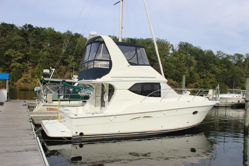 Slide: The Image of 2007 Silverton 36 Convertible yacht docked at a marina, surrounded by lush greenery. - 3