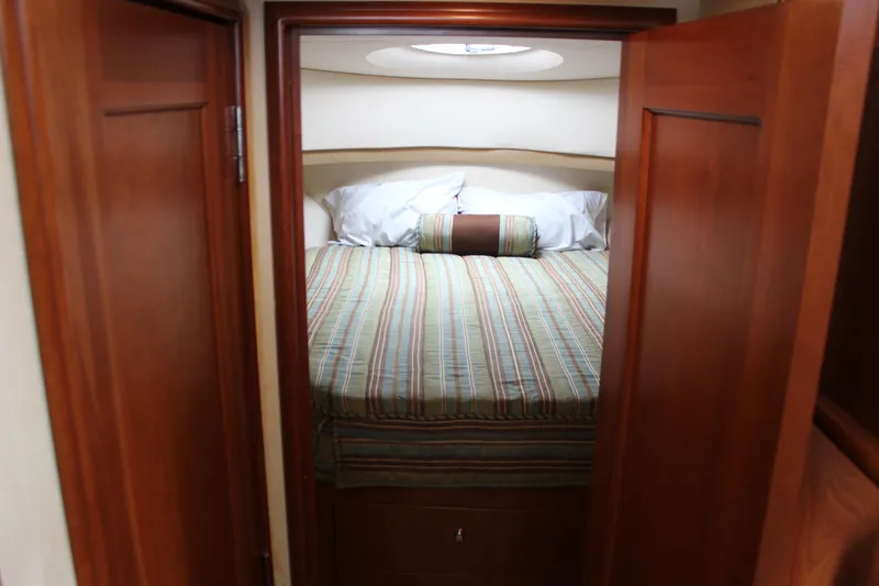 Slide: The Image of Cozy bedroom in 2007 Silverton 36 Convertible yacht with striped bedding and wooden doors. - 30