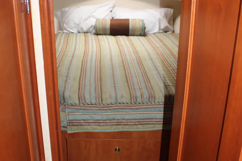 Slide: The Image of Cozy bedroom in 2007 Silverton 36 Convertible yacht with striped bedding. - 31