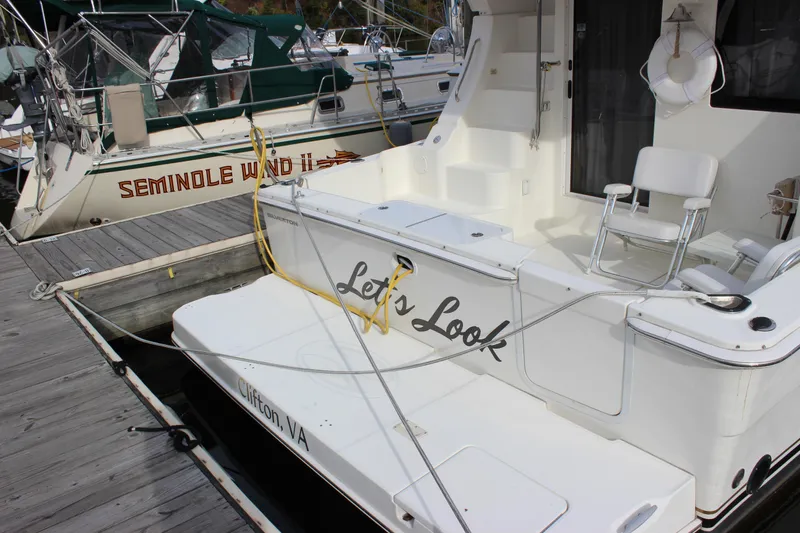 Slide: The Image of 2007 Silverton 36 Convertible yacht docked, featuring spacious deck and seating area. - 5