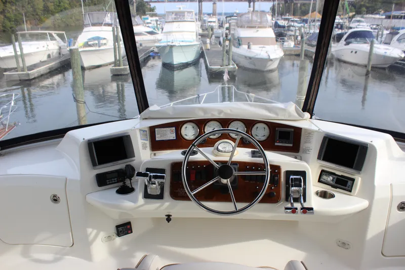 Slide: The Image of 2007 Silverton 36 Convertible yacht helm with steering wheel and control panel at marina. - 9