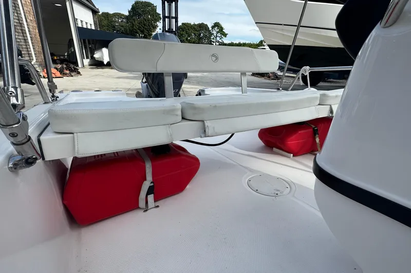 Slide: The Image of 2016 Edgewater 158CS boat interior with white seating and red fuel tanks. - 13