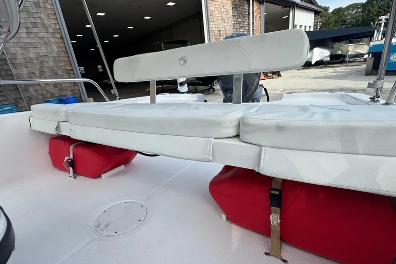 Slide: The Image of 2016 Edgewater 158CS boat interior with white seating and red storage compartments. - 15