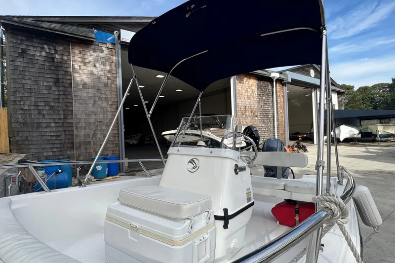 Slide: The Image of 2016 Edgewater 158CS boat with canopy, docked near wooden storage building. - 18