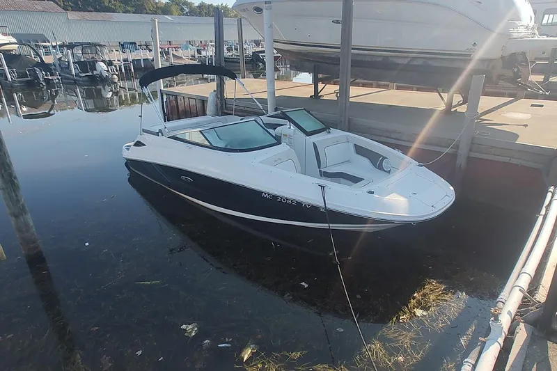 Slide: The Image of 2013 Sea Ray 220 Sundeck boat docked at a marina under sunlight. - 3