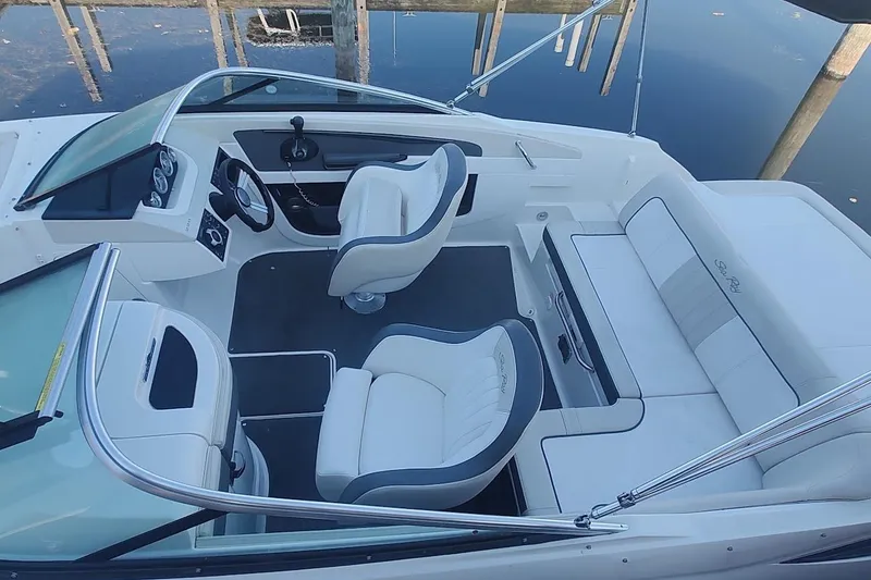 Slide: The Image of 2013 Sea Ray 220 Sundeck interior with white seating and sleek dashboard design. - 6