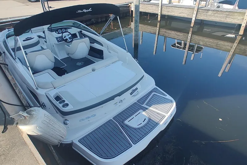 Slide: The Image of 2013 Sea Ray 220 Sundeck boat docked at marina, rear view. - 8