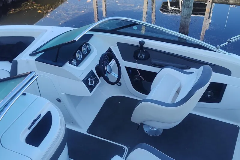 Slide: The Image of 2013 Sea Ray 220 Sundeck boat interior with steering wheel and dashboard controls. - 9