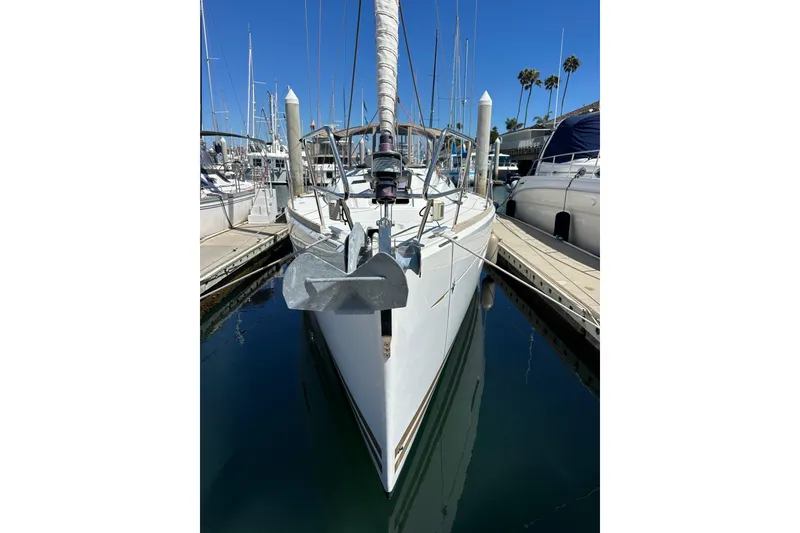 Slide: The Image of 2015 Jeanneau Sun Odyssey 409 sailing near urban skyline and naval ship. - 2