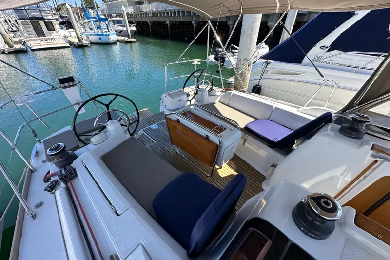 Slide: The Image of 2015 Jeanneau Sun Odyssey 409 sailboat deck with rigging, docked in marina under clear blue sky. - 22
