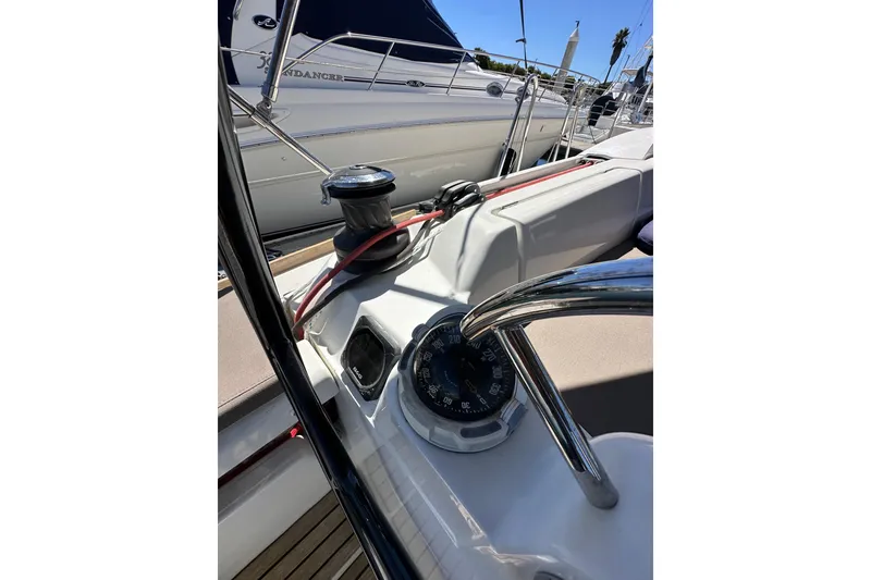 Slide: The Image of 2015 Jeanneau Sun Odyssey 409 cockpit with seating, navigation equipment, and marina view. - 33