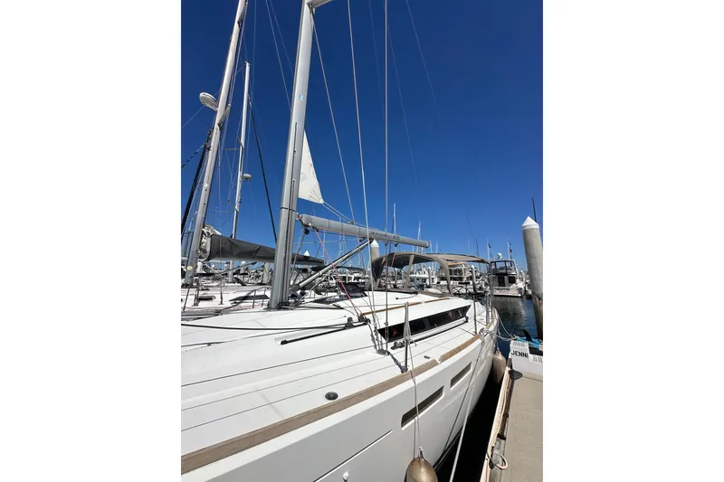 Slide: The Image of 2015 Jeanneau Sun Odyssey 409 sailboat docked at marina under clear blue sky. - 5