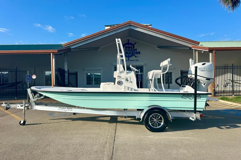 The Image of 2026 Shallow Sport 18 Sport boat on trailer outside marine store. - 0