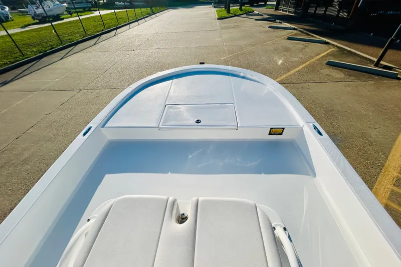 Slide: The Image of 2026 Shallow Sport 18 Sport boat, white deck, parked on concrete surface. - 11