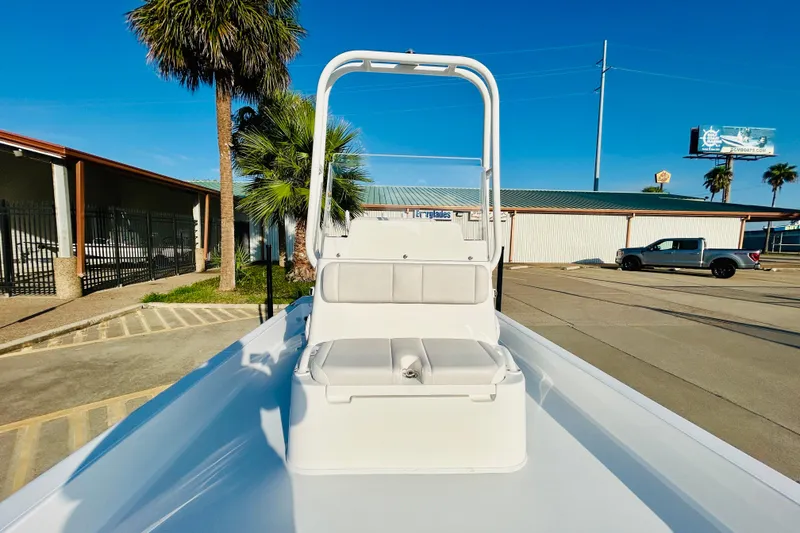 Slide: The Image of 2026 Shallow Sport 18 Sport boat with seating, parked near palm trees and buildings. - 13