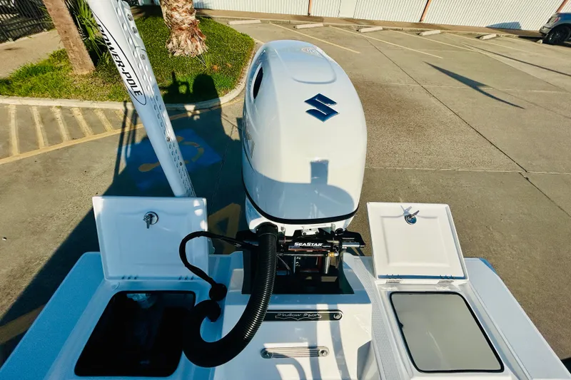 Slide: The Image of 2026 Shallow Sport 18 Sport boat with Suzuki outboard motor in a parking lot. - 16