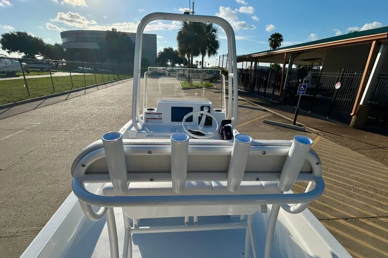 Slide: The Image of 2026 Shallow Sport 18 Sport boat with rod holders, parked outdoors under a clear sky. - 17