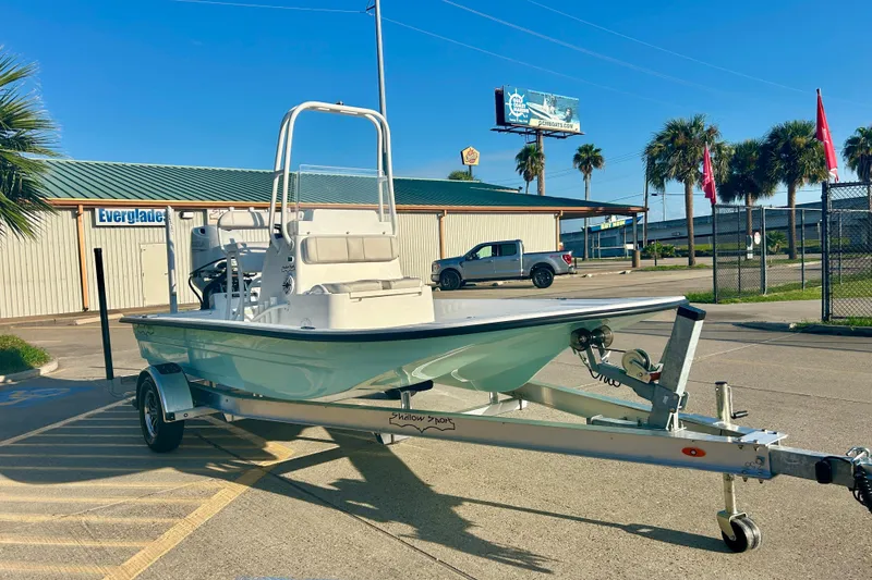 Slide: The Image of 2026 Shallow Sport 18 Sport boat on trailer, parked outdoors near palm trees. - 3
