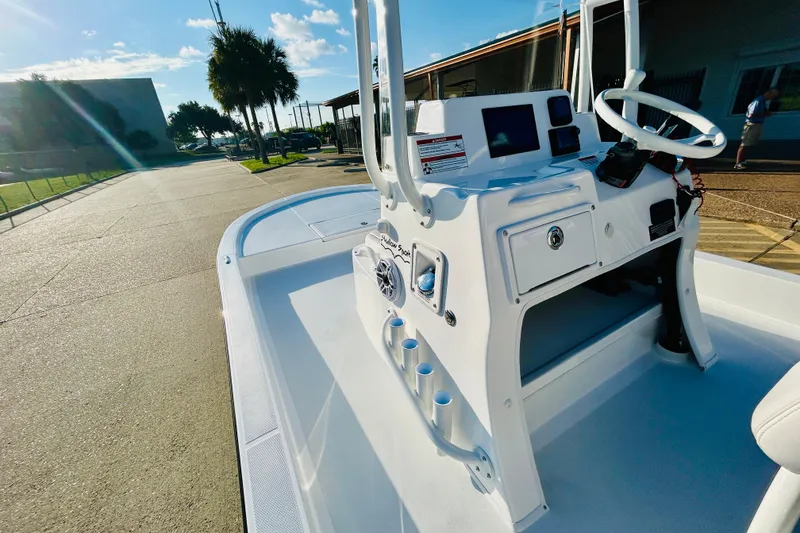 Slide: The Image of 2026 Shallow Sport 18 Sport boat with sleek console and steering, parked outdoors. - 9