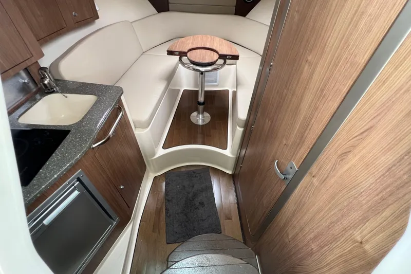 Slide: The Image of 2019 Boston Whaler 315 Conquest cabin interior with kitchenette and seating area. - 11