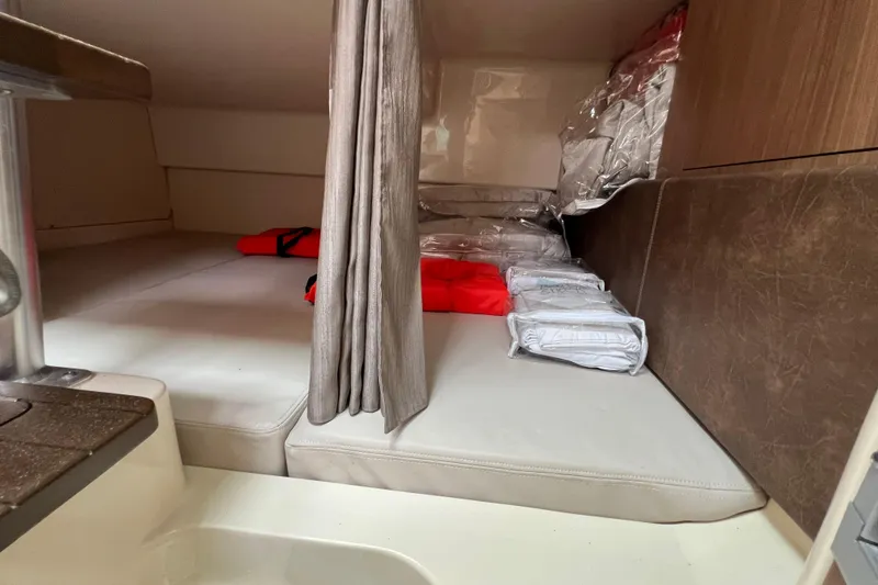 Slide: The Image of 2019 Boston Whaler 315 Conquest cabin interior with life jackets and cushions. - 17