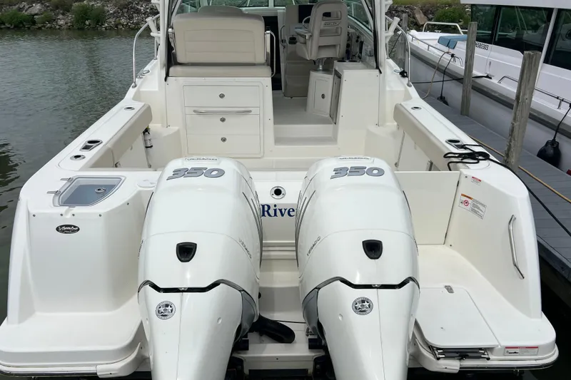 Slide: The Image of 2019 Boston Whaler 315 Conquest boat with twin 350 engines docked at marina. - 2