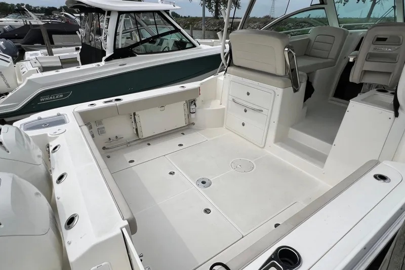 Slide: The Image of 2019 Boston Whaler 315 Conquest boat interior with seating and storage. - 6