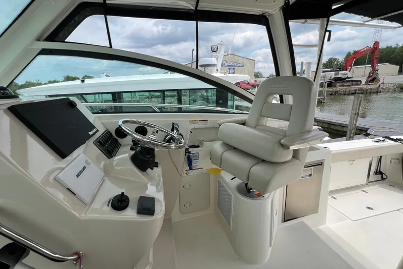 Slide: The Image of 2019 Boston Whaler 315 Conquest helm with steering wheel and captain's chair. - 7