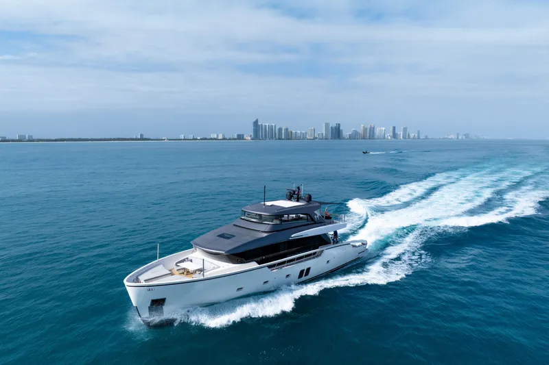 Slide: The Image of Sanlorenzo SX88 2020 yacht cruising on blue ocean with city skyline in background. - 27
