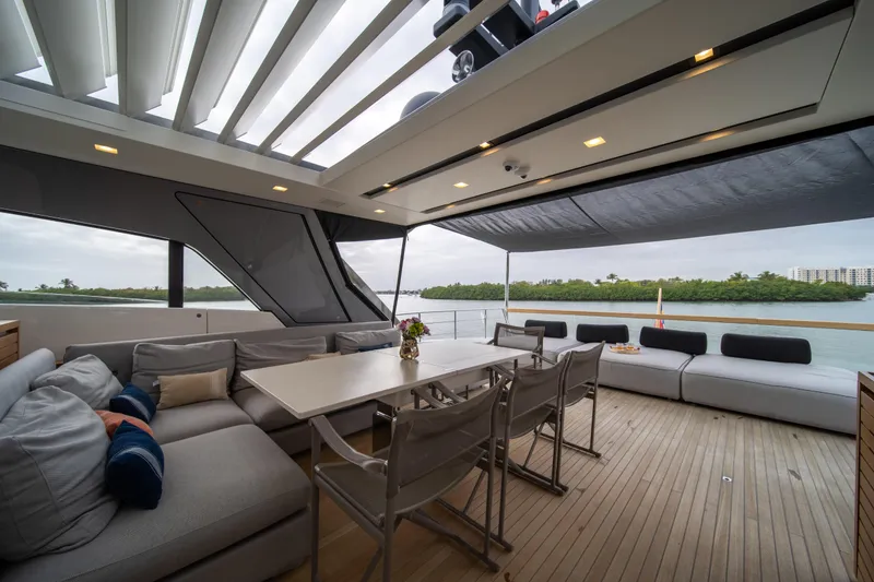 Slide: The Image of Luxurious 2020 Sanlorenzo SX88 yacht deck with elegant seating and dining area, overlooking serene waters. - 51