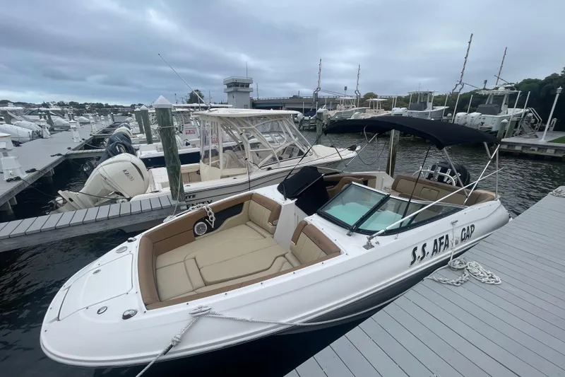 Slide: The Image of 2014 Sea Ray 240 Sundeck Outboard boat docked, featuring spacious seating and sleek design. - 1