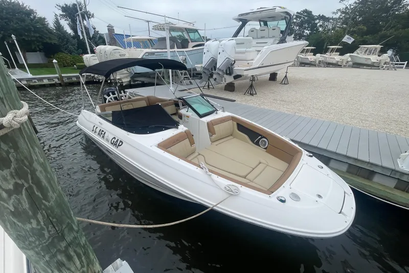 Slide: The Image of 2014 Sea Ray 240 Sundeck Outboard docked, featuring spacious seating and sleek design. - 2