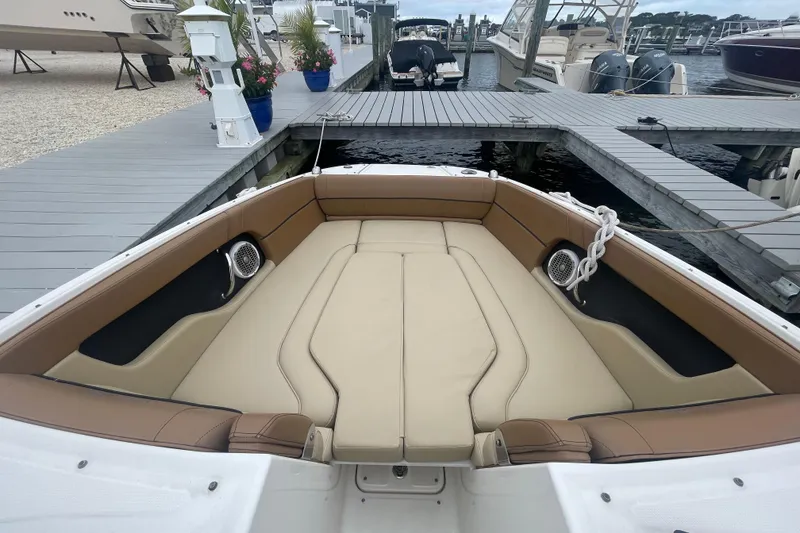 Slide: The Image of 2014 Sea Ray 240 Sundeck Outboard with spacious seating at a marina dock. - 3