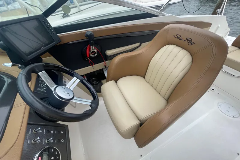 Slide: The Image of 2014 Sea Ray 240 Sundeck Outboard helm with steering wheel and captain's chair. - 5