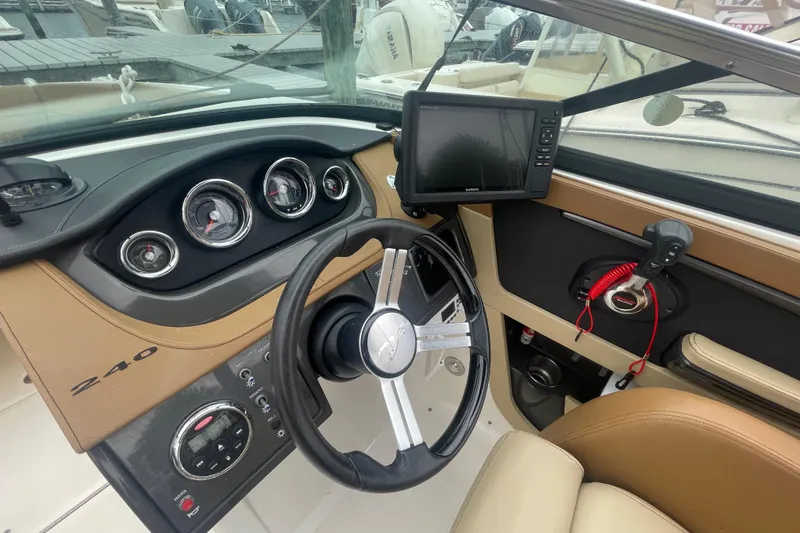 Slide: The Image of 2014 Sea Ray 240 Sundeck Outboard dashboard with steering wheel and navigation system. - 6