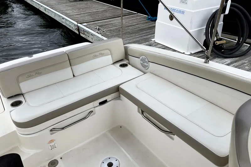Slide: The Image of 2013 Sea Ray 280 Sundeck boat interior with white seating near dock. - 15