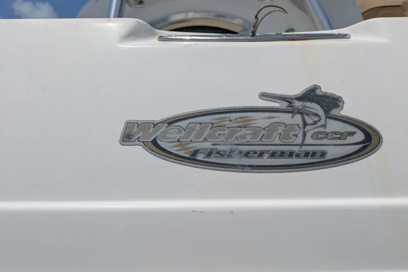 Slide: The Image of 2004 Wellcraft 29 CCF Fisherman logo on white boat surface. - 8