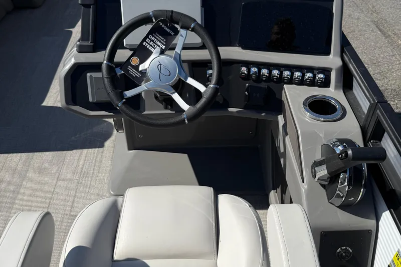 Slide: The Image of 2025 Qwest Splash Pad L-Class boat dashboard with steering wheel and controls. - 5