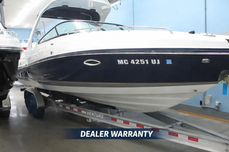 The Image of 2018 Rinker QX29 CC boat on trailer with dealer warranty displayed. - 0
