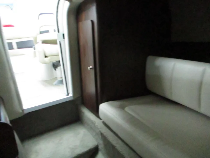 Slide: The Image of 2018 Rinker QX29 CC boat interior with compact portable toilet. - 11