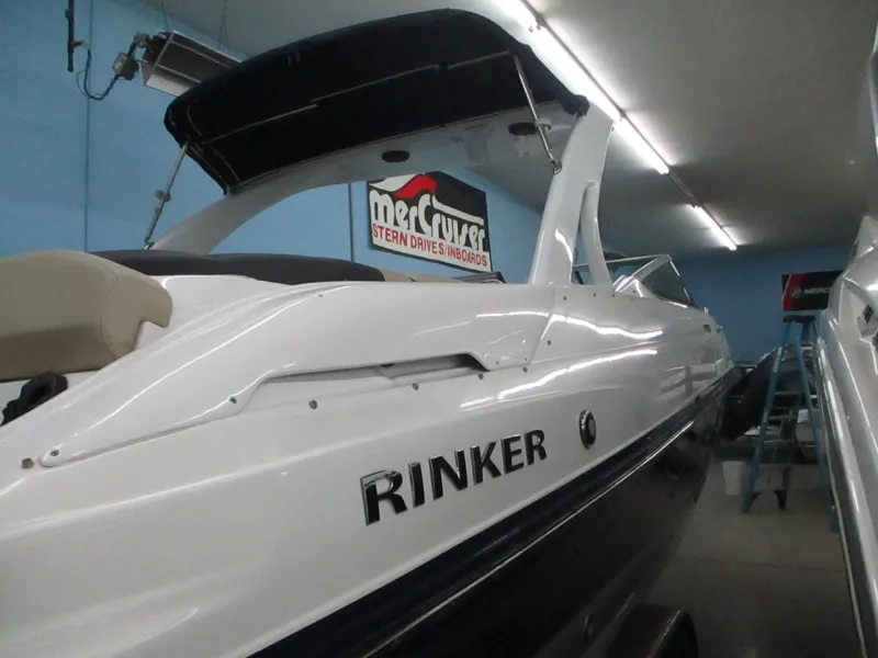 Slide: The Image of 2018 Rinker QX29 CC boat model emblem on white surface. - 17
