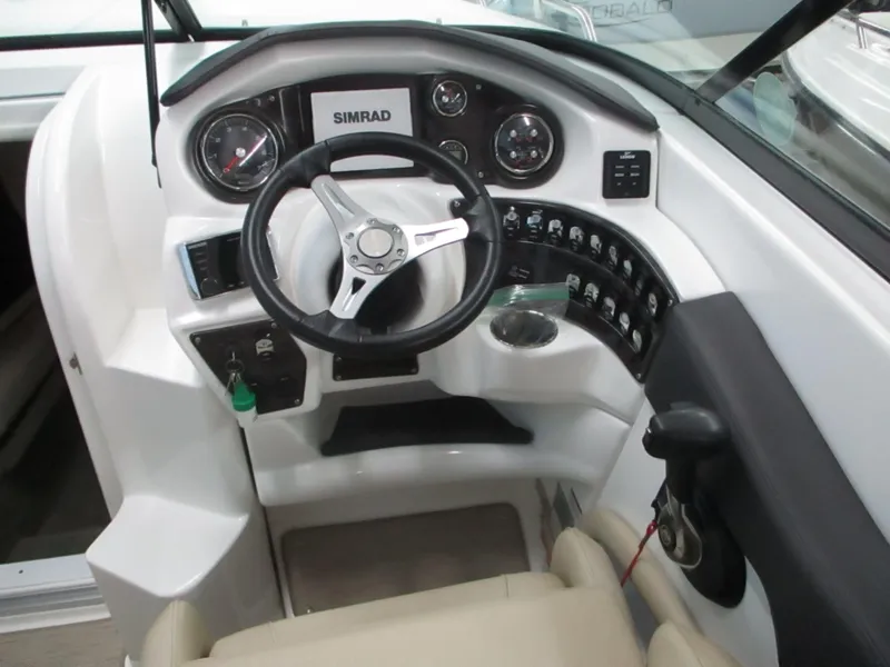 Slide: The Image of Captain's seat and helm of 2018 Rinker QX29 CC boat, featuring modern controls. - 6