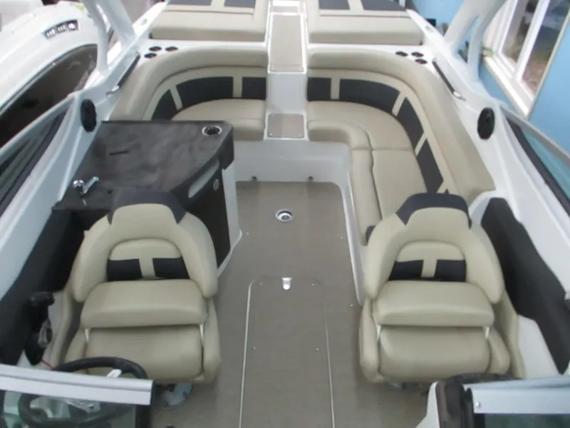 Slide: The Image of 2018 Rinker QX29 CC boat interior with steering wheel and cabin entrance. - 8